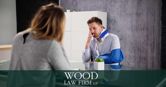 Man in Cast Talking to Woman at Desk